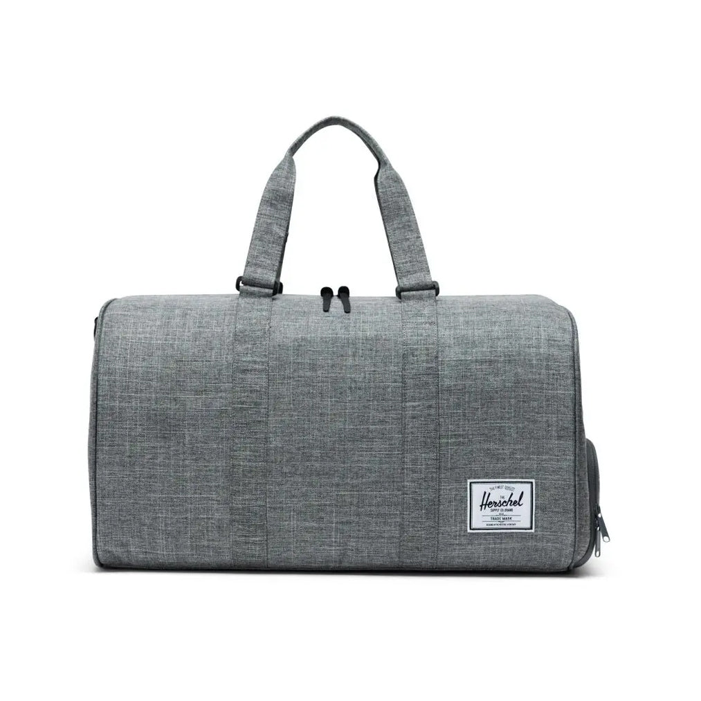 Gray duffel bag with two handles and a side zipper, featuring a white logo patch.
