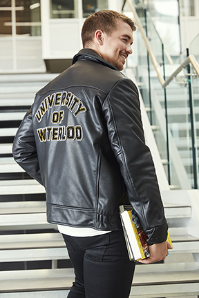 Student wearing a leather jacket with University of Waterloo in felt letters on the back