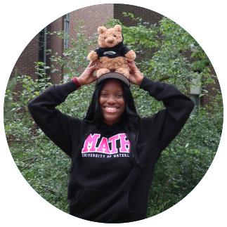 Student wearing math hoodie holding stuffed bear over their head