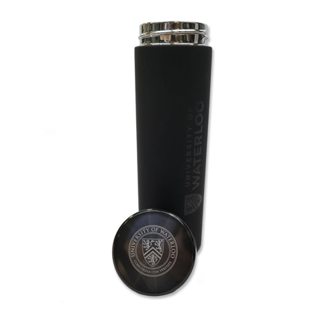 A black insulated water bottle with a metallic lid, featuring the University of Waterloo logo engraved on the side, next to a round, silver-colored coaster with the same logo.