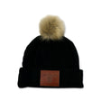 Black knit beanie with a fur pom-pom on top and a leather patch that reads "University of Waterloo."