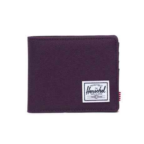 Purple wallet with a white Herschel logo patch on the front.