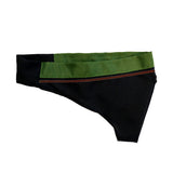 A black and green fabric item, possibly a piece of clothing or accessory, featuring a smooth green top section and a black lower section with decorative stitching.