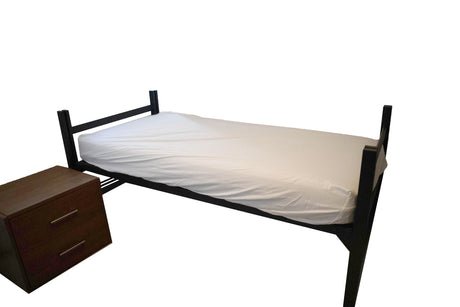 A single bed with a white mattress cover and a wooden nightstand with two drawers beside it.